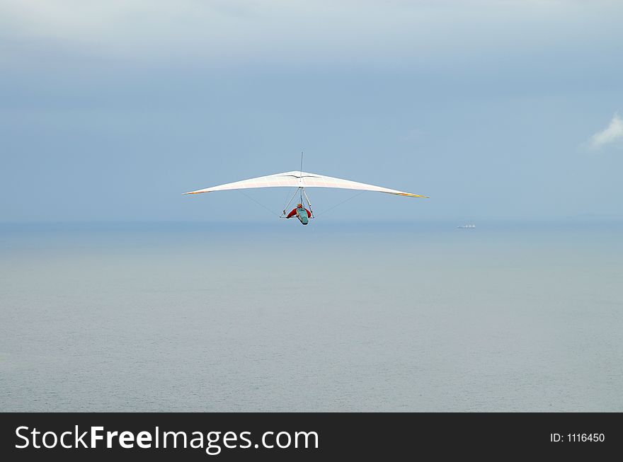 Man flying with a hang glider off the coast of Australia. Man flying with a hang glider off the coast of Australia