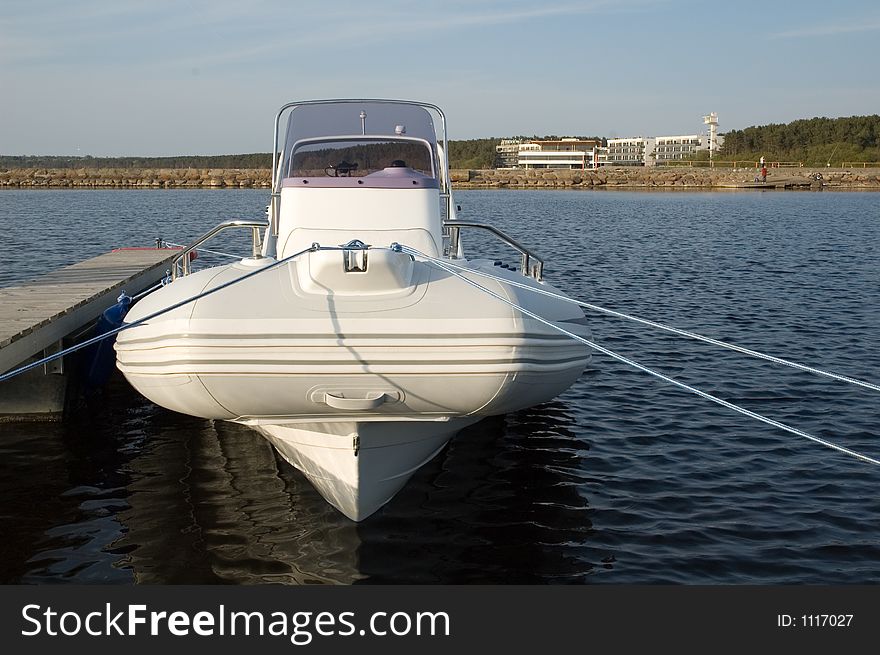 Modern lightweight speedboat docked safely in the harbour. Modern lightweight speedboat docked safely in the harbour.