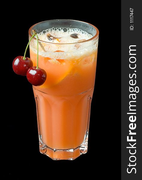 Carrot juice cocktail with cherries, isolated over black background.