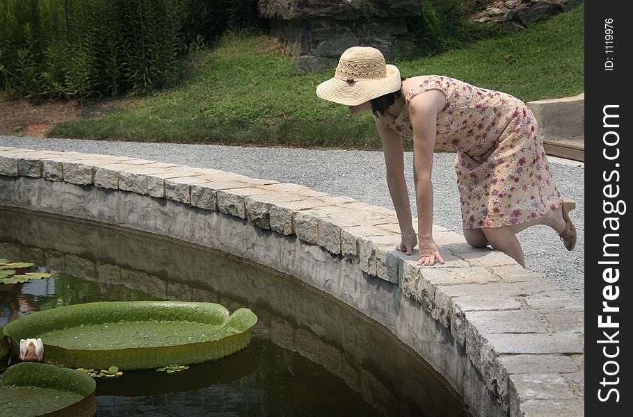 Woman in straw hat with flat lily pads. Woman in straw hat with flat lily pads