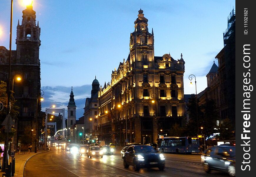 Downtown Budapest Ferenciek tere at sundown in monochrome with car traffic and evening lights in color. Downtown Budapest Ferenciek tere at sundown in monochrome with car traffic and evening lights in color