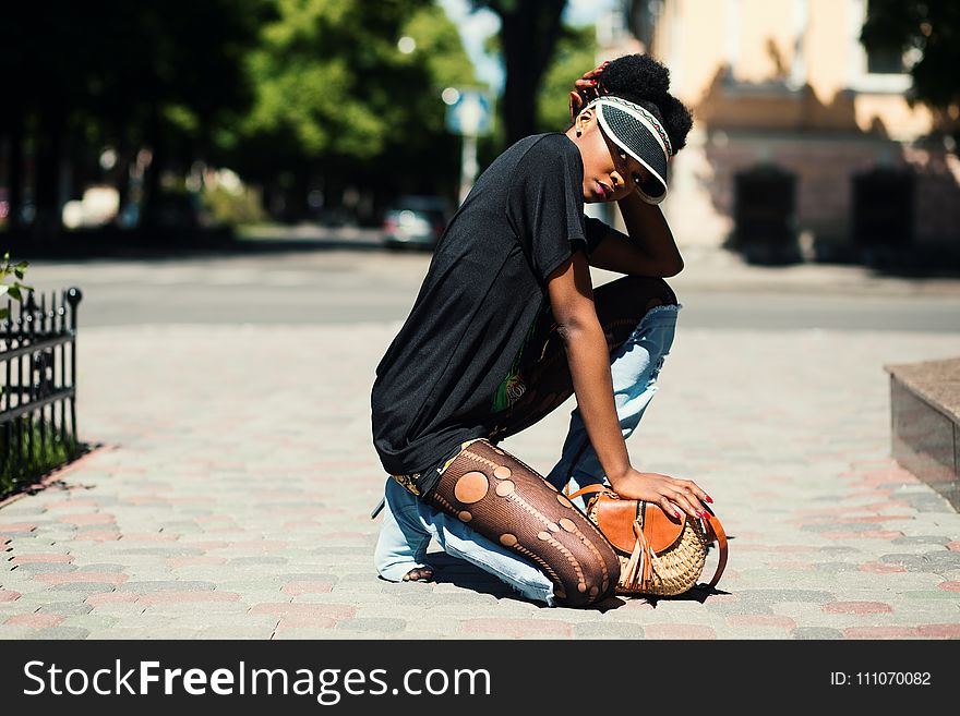 Woman Wearing Black T-shirt Kneeling on Ground