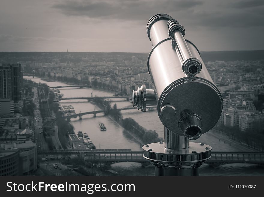 Grayscale Photography Of Observation Telescope Overlooking City Riverbank