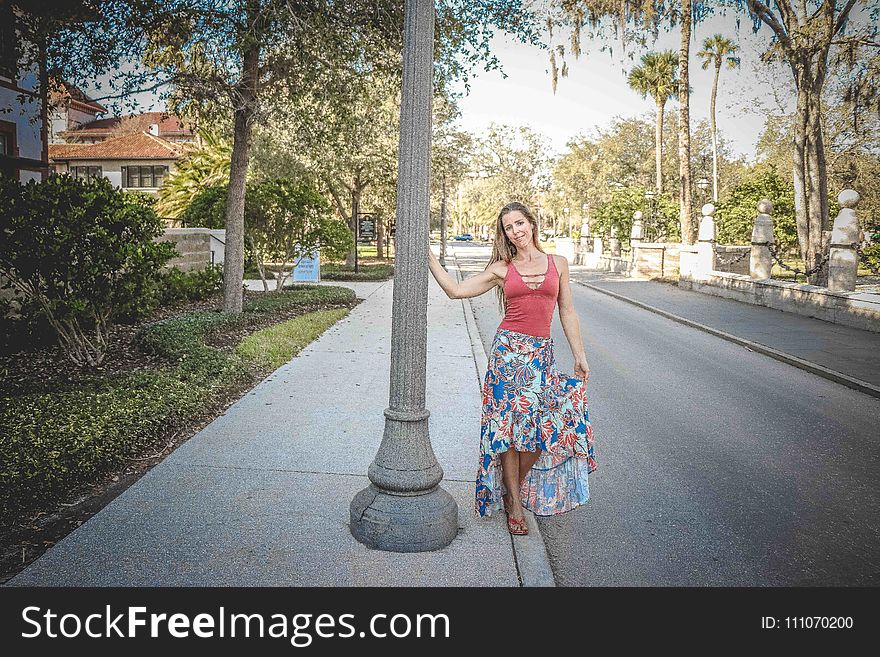 Woman Wearing Red and Blue Floral Tank Dress Beside Concrete Road