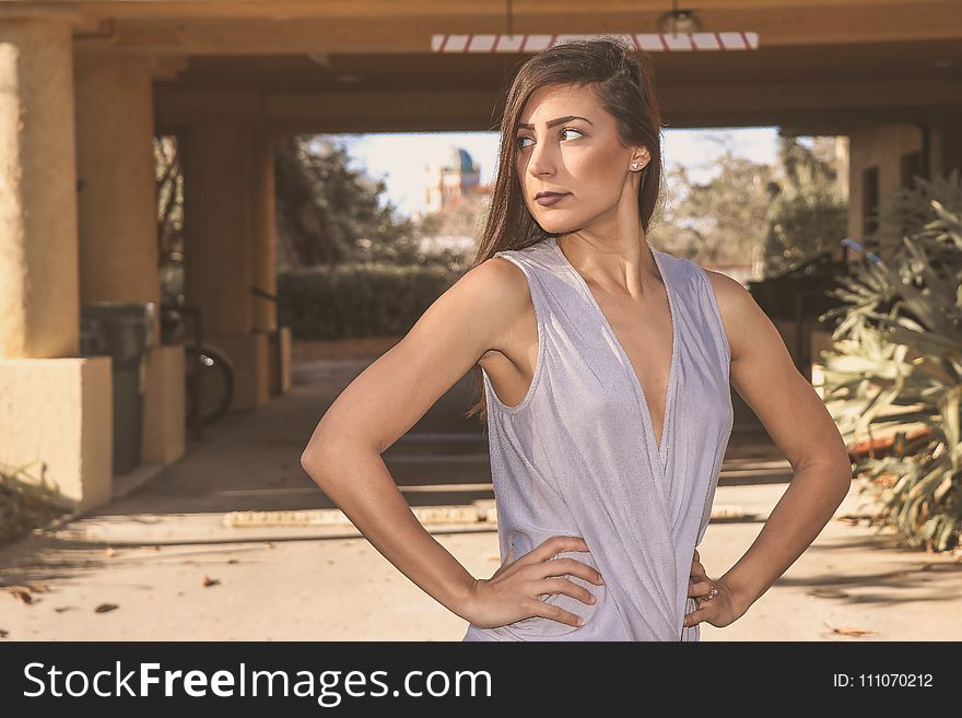 Woman in Gray Sleeveless Top Standing in Front White Bridge