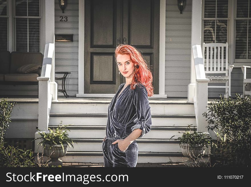 Woman in Gray Jumpsuit Standing in Front of House