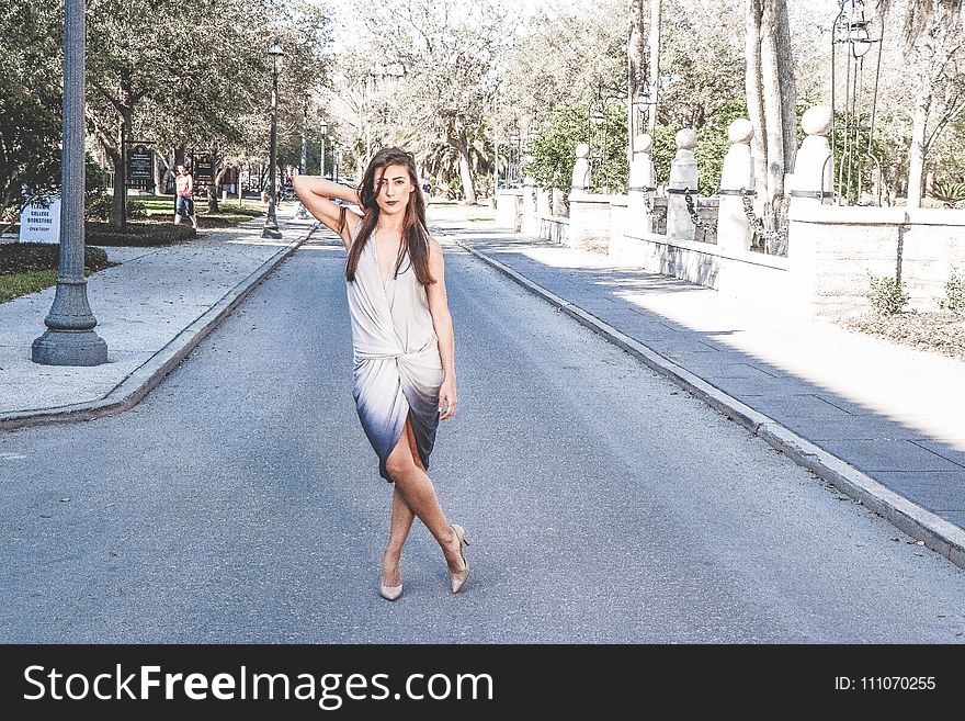 Woman Standing on Street With Cross Leg