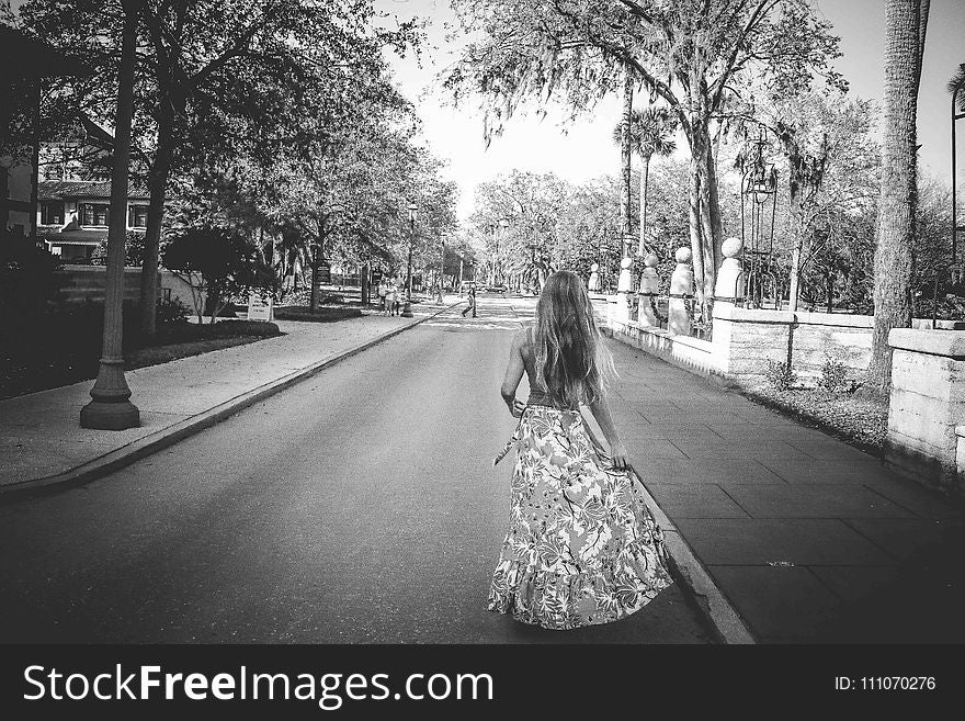 Woman in Floral Dress Standing on Road
