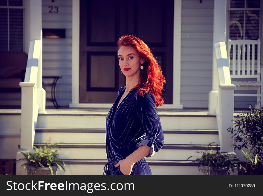 Woman Standing In Front Of White Wooden House