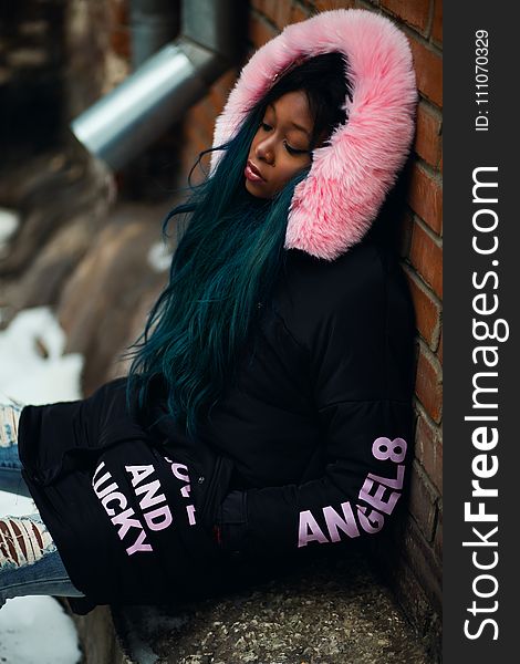 Woman Wearing Black and Pink Coat Leaning on Wall