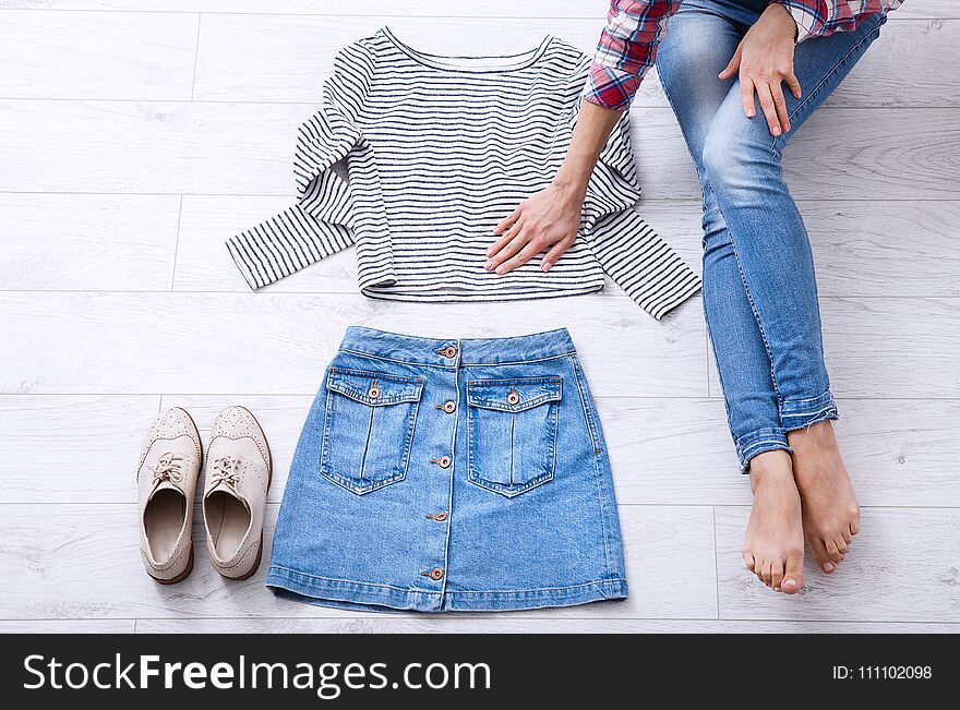 Fashion outfit with female body parts on white wooden background. Top view and copy space.