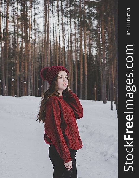 Woman Wearing Red Sweater and Red Beanie Under Forest