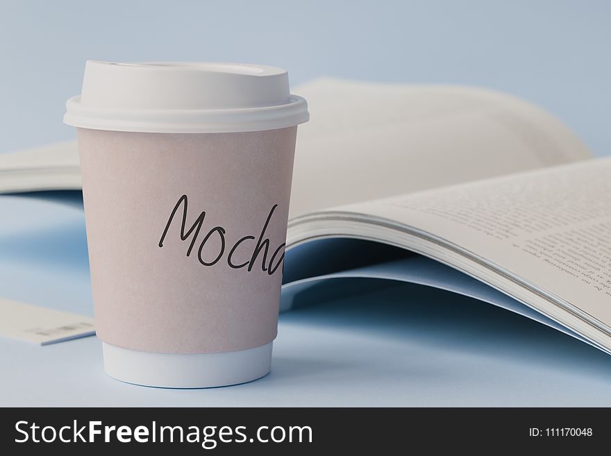 Mocha Labeled White Disposable Coffee Cup Beside Book