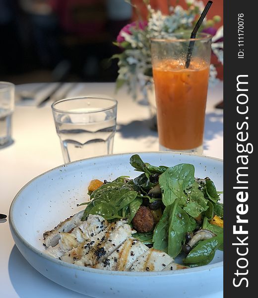 Selective Focus Photography of Cooked Food With Vegetables in Plate Near Glass of Water