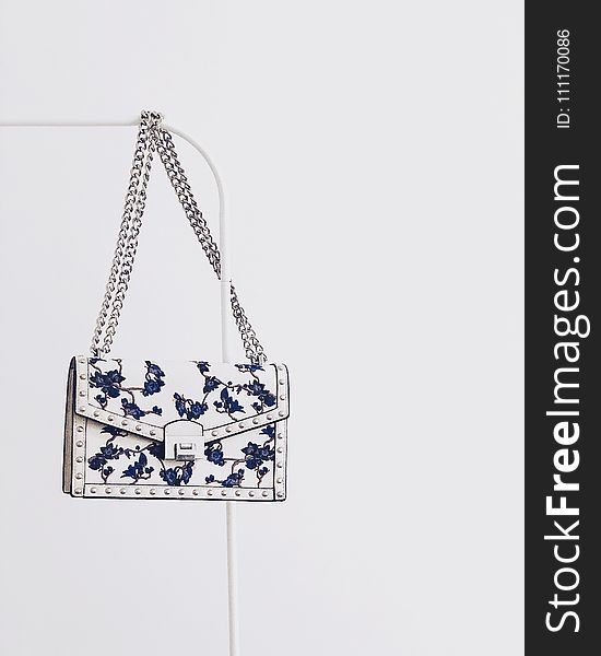 White and Blue Floral Flap Sling Bag Hanging on White Steel Rack