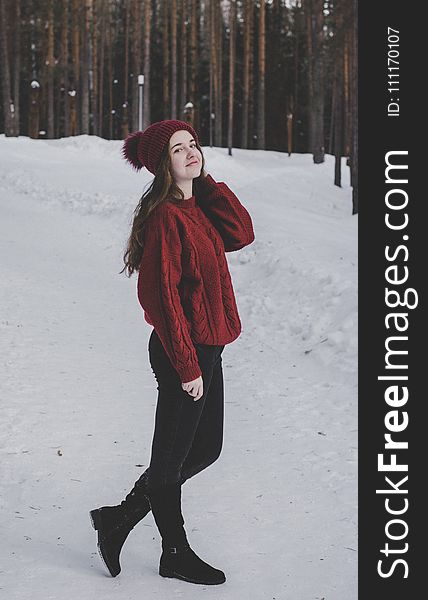 Woman Wearing Knitted Sweater With Hat On Snowfield