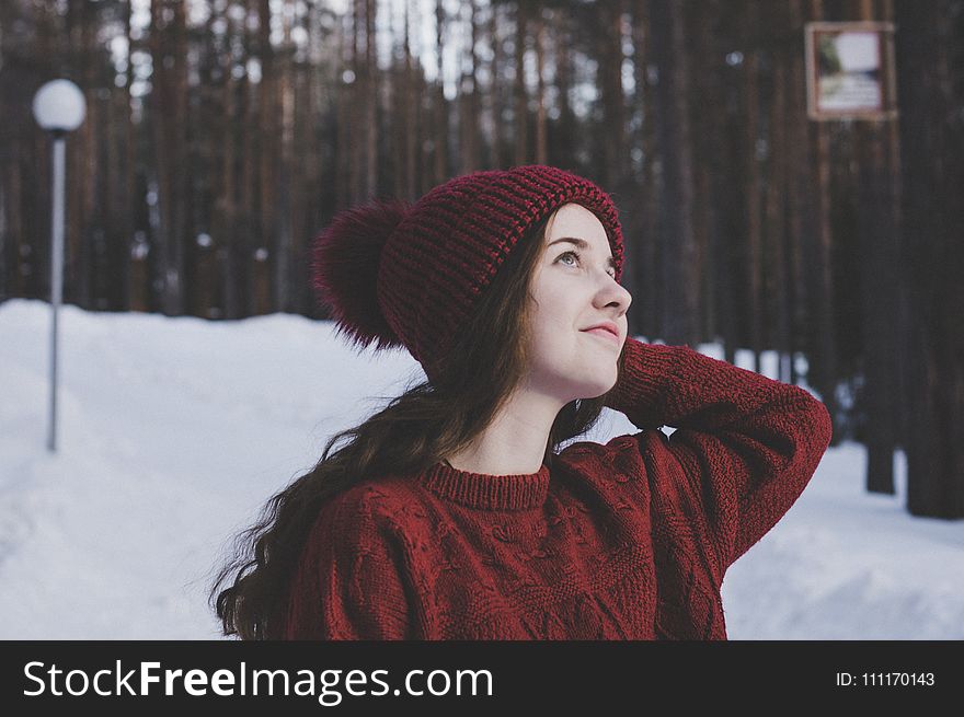 Woman Wearing Maroon Bobble Beanie On Winter Day