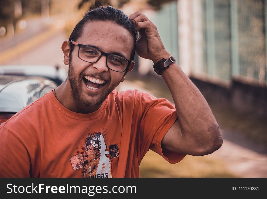Selective Focus Photography of Man Smiling Putting Hands on Head