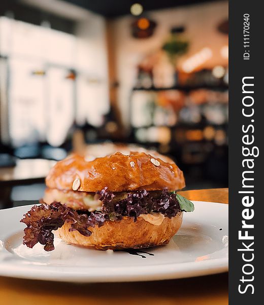 Selective Focus Photography Of Burger On White Ceramic Plate