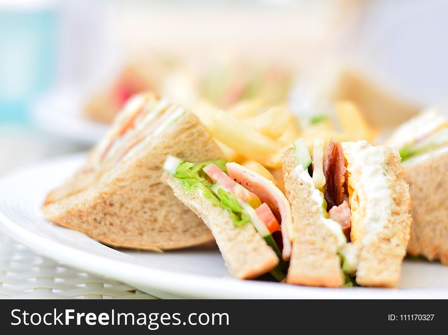 Selective Focus Photography of Plate of Sliced Clubhouse Sandwich