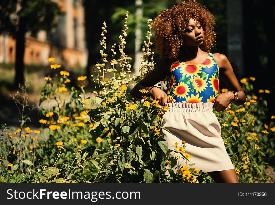 Photography of Woman Wearing Blue, Yellow and Red Floral Tank Top Standing