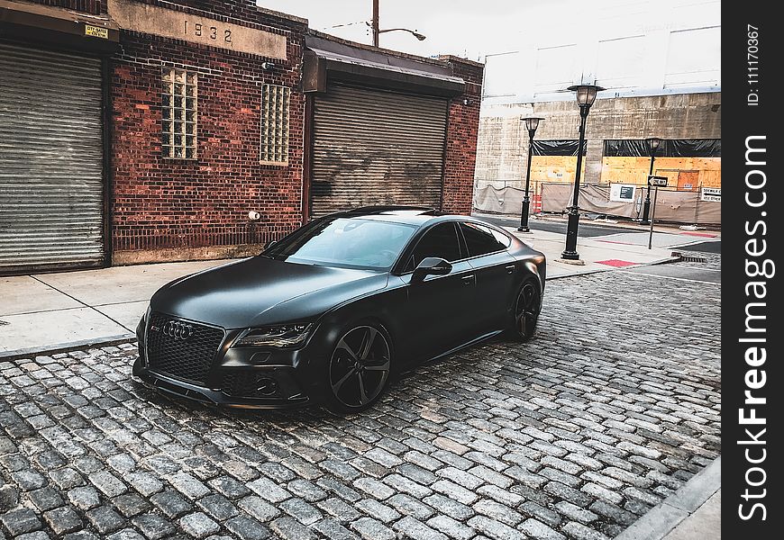 Black Audi A-series Parked Near Brown Brick House