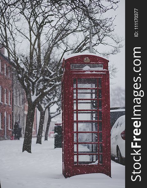 Red Telephone Booth On The Sidewalk With Snow