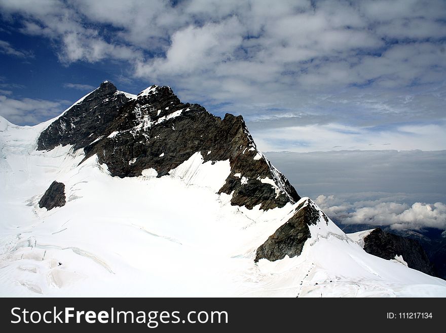 Snow Capped Mountain Under Cloudy Sky