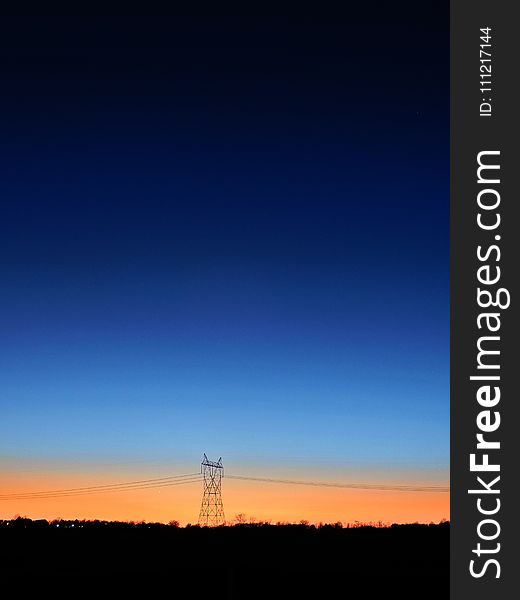 Black Transmitter Tower Under Blue and Orange Sky