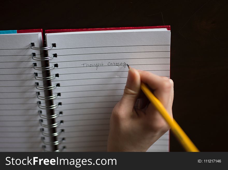Person Writing on White Lined Paper