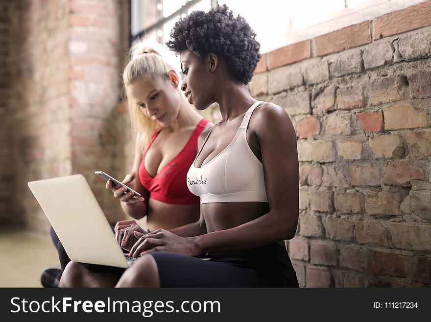 Two Woman Wearing Red and White Sports Bras