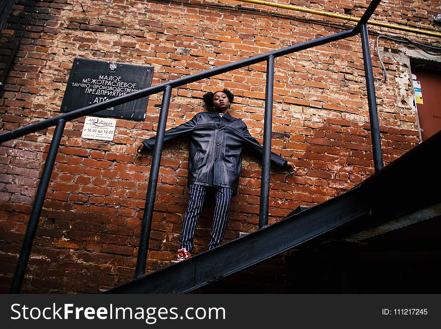 Woman In Black Jacket Standing On The Stairs