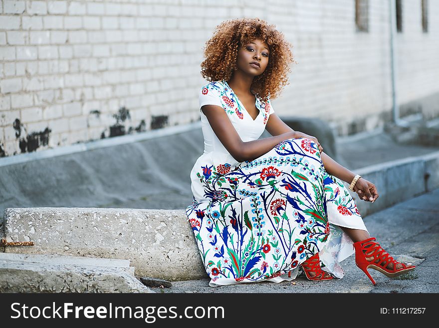 Woman Sitting on Concrete Block Wearing Red Strap Heels