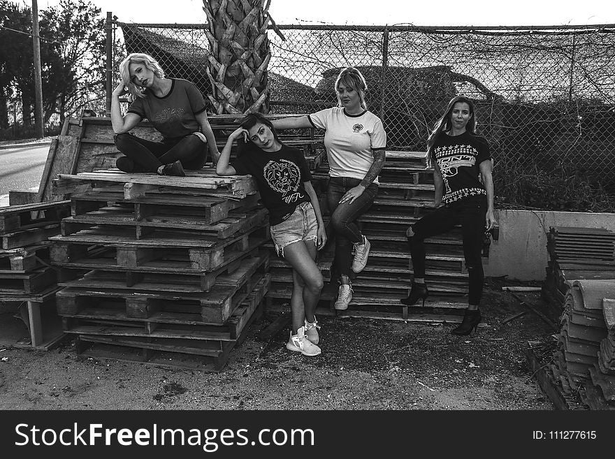 Four Women Leaning and Sitting on Pallets