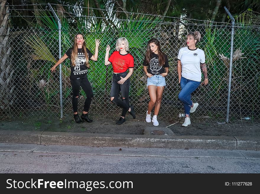 Group of Women Standing in Front Metal Fence