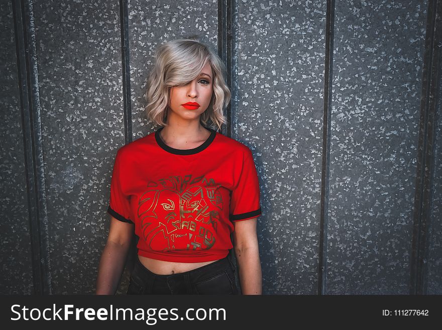 Woman in Red Shirt Standing Near Wall