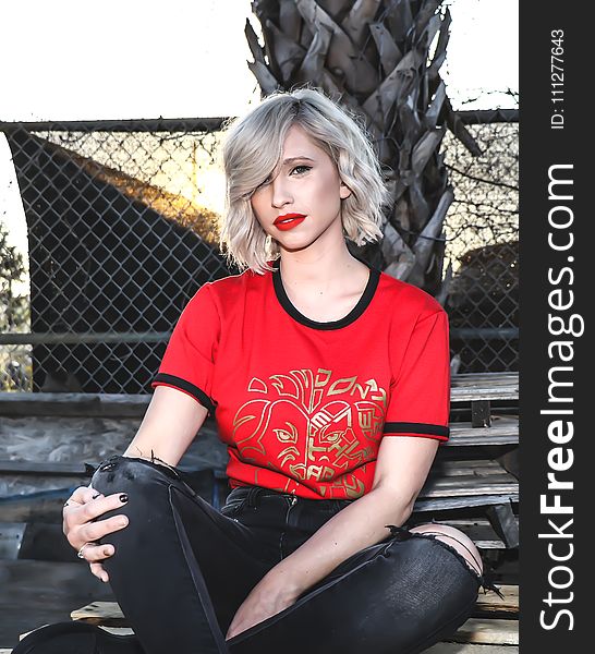 Woman in Red Crew-neck Shirt Sitting in Bench