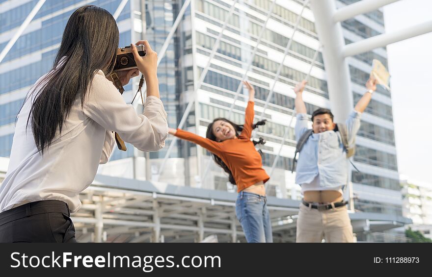 Business women hold camera to shoot the traveler couple people at urban city and modern building. Honeymoon trip, holiday vacation travel concept. Business women hold camera to shoot the traveler couple people at urban city and modern building. Honeymoon trip, holiday vacation travel concept.