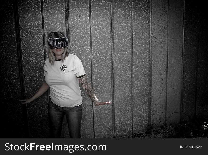 Woman Wearing Virtual Reality Headset Standing Beside Wall