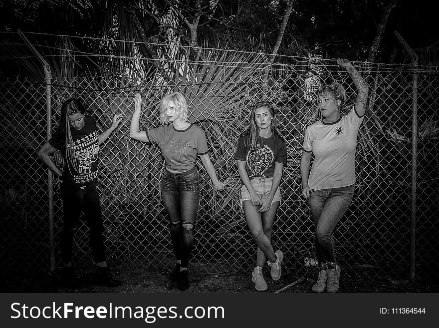 Four Women Standing Near Chain Fence