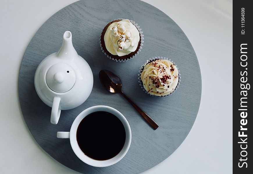 White Ceramic Cup and Teapot with Cupcakes