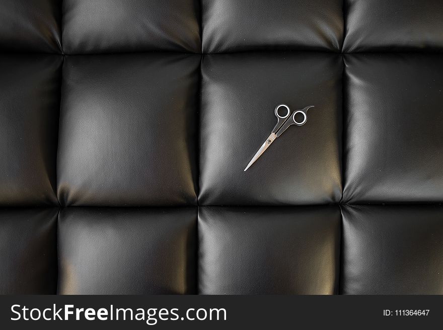 Photo of Scissor on Black Leather Cushion