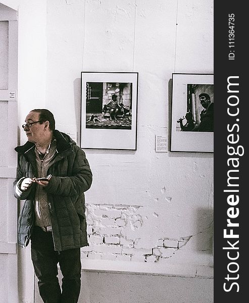 Man Standing in Front of Grayscale Gallery Photo