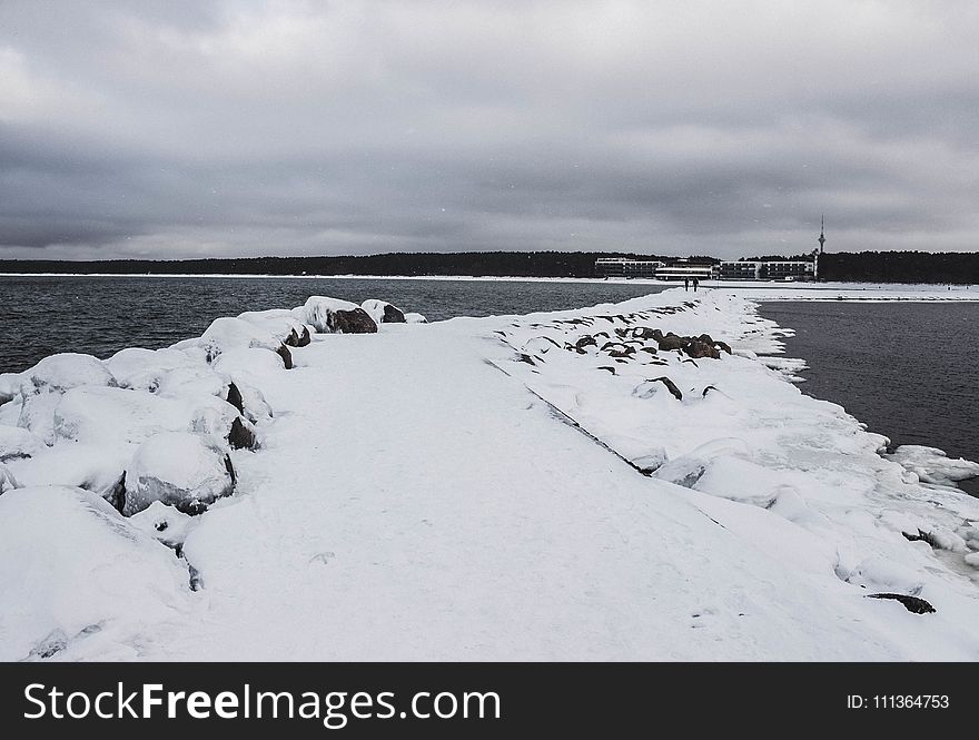 Pathway Between Body of Water Filled With Snow