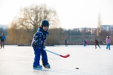 Children, Playing Hockey And Skating In The Park On Frozen Lake, Wintertime On Sunset Royalty Free Stock Images Children, Playing Hockey And Skating In The Park On Frozen Lake, Wintertime On Sunset Royalty Free Stock Images