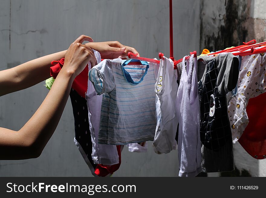 Drying clothes, the woman`s hand is holding the clothes to be dried, version 1. Drying clothes, the woman`s hand is holding the clothes to be dried, version 1