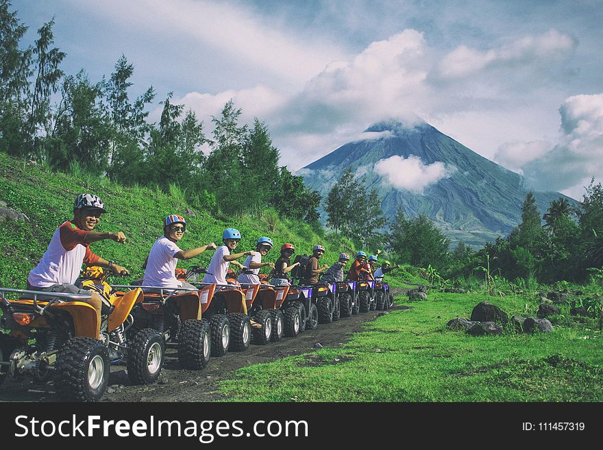 Line Of Men Riding On All Terrain Vehicles Holding Out Hand In A Fist
