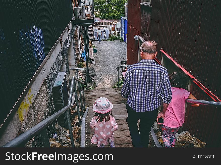 Man and Two Girls Walking Down on Stairs