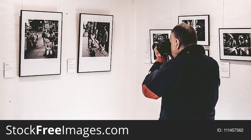 Man Taking Photo Inside Exhibit Room