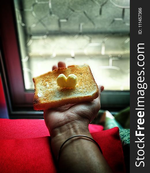 Person Holding Toast With Butter on Top
